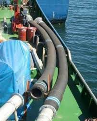 Two armoured suction hoses run over the side of a working barge into the water alongside. Two armoured suction hoses run over the side of a working barge into the water alongside.