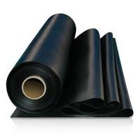 Rolls of black rubber sheeting standing and lying together, one wound on a cardboard core. Rolls of black rubber sheeting standing and lying together, one wound on a cardboard core.