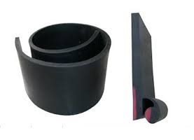 A roll of skirt board rubber beside a cut length of it standing on end, showing the thickness of the strip. A roll of skirt board rubber beside a cut length of it standing on end, showing the thickness of the strip.