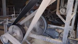 A long flat belt running between two pulleys in a rice mill. A long flat belt running between two pulleys in a rice mill.