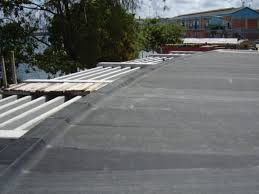 An EPDM membrane laid across a flat roof, with rolls of it still to be unrolled along the edge. An EPDM membrane laid across a flat roof, with rolls of it still to be unrolled along the edge.