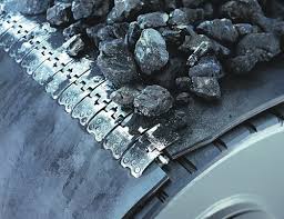 A belt loaded with lump coal running over its pulley, the fastener plates joining the two ends. A belt loaded with lump coal running over its pulley, the fastener plates joining the two ends.