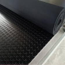 A roll of anti slip rubber flooring part unwound, round studs raised across its face.