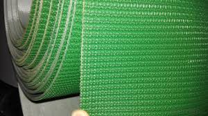 A green rough top belt, its woven grip surface running away from the camera. A green rough top belt, its woven grip surface running away from the camera.