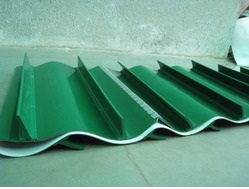 A green PVC belt with tall V cleats moulded across it, laid out on a floor. A green PVC belt with tall V cleats moulded across it, laid out on a floor.