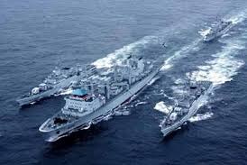 Two naval vessels under way at sea, seen from the air.
